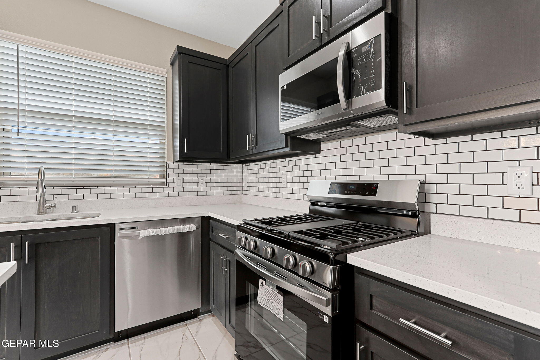 609 Espa Court Vinton, TX 79821 - Photo 3 of 19 a kitchen with stainless steel appliances a sink stove and microwave