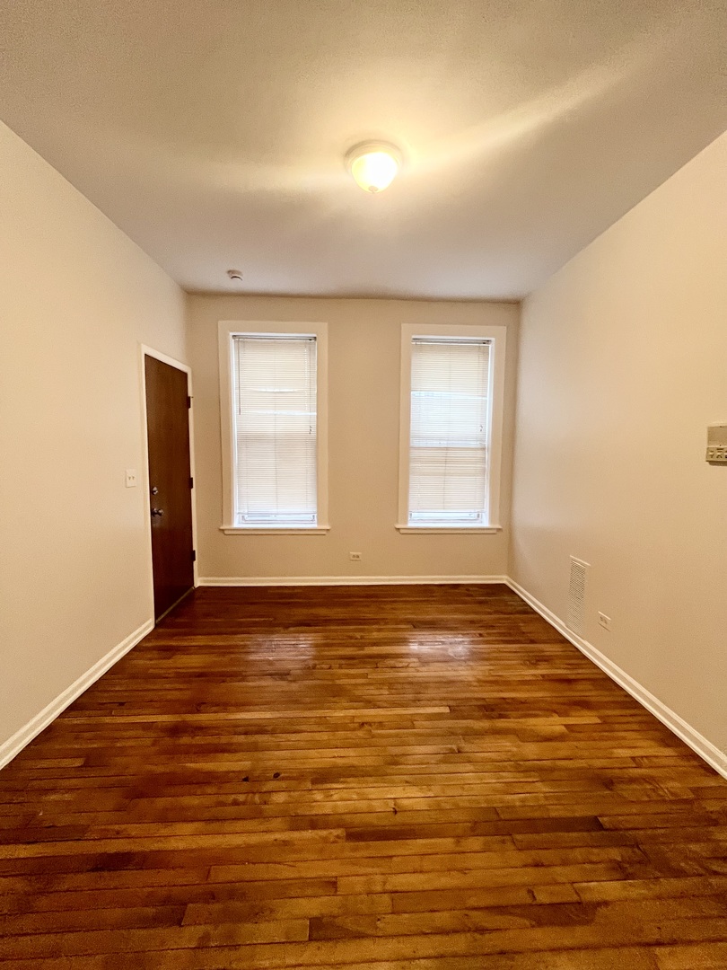 3227 South Carpenter Street, Unit 1M Chicago, IL 60608 - Photo 13 of 14 a view of an empty room with wooden floor and a window