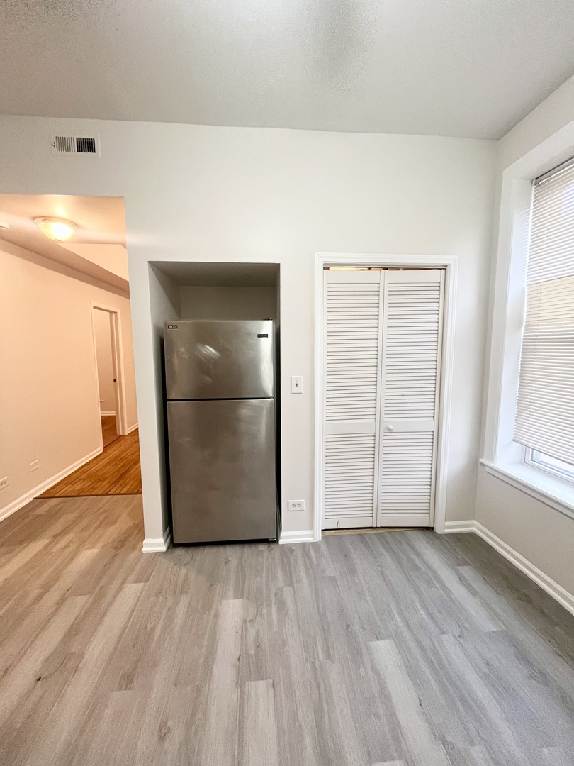 3227 South Carpenter Street, Unit 1M Chicago, IL 60608 - Photo 2 of 14 an empty room with wooden floor and door
