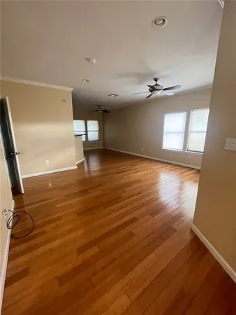 wooden floor in an empty room with a kitchen