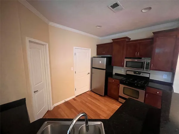 a kitchen with granite countertop a refrigerator stove and oven