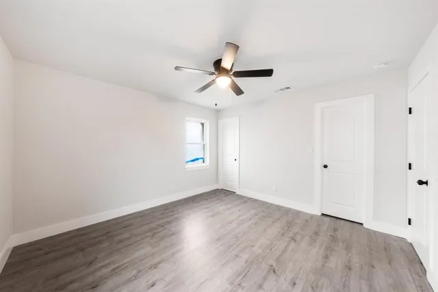 a view of a room with wooden floor and a ceiling fan