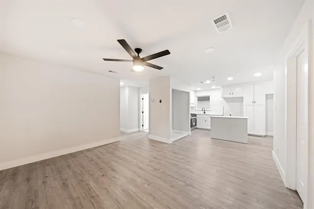 a view of an empty room and kitchen view