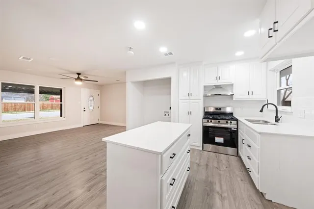 a kitchen with granite countertop a sink stove and refrigerator