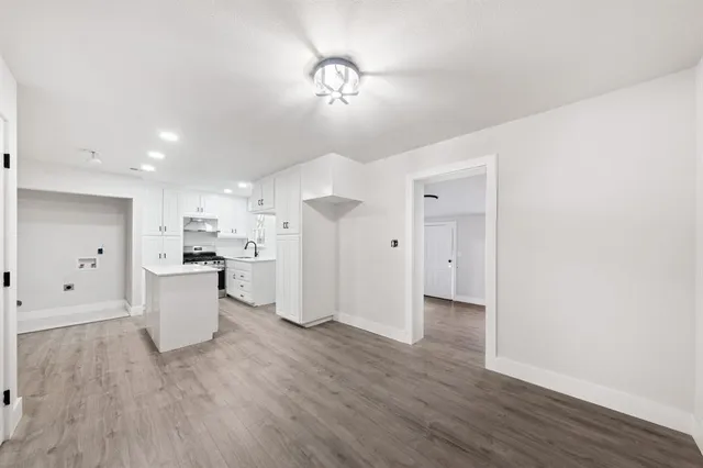 a view of a kitchen with a sink and wooden floor