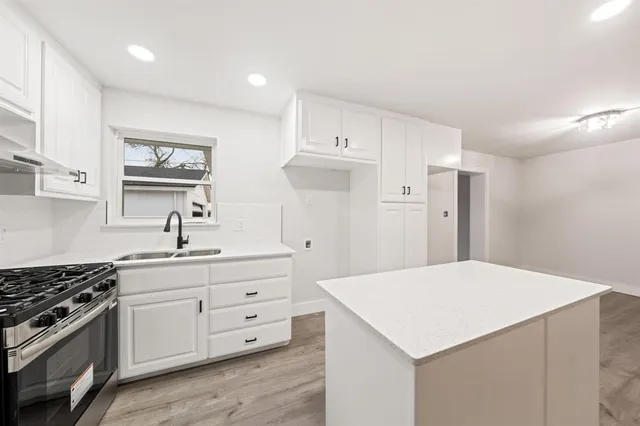 a kitchen with a stove a sink and a refrigerator
