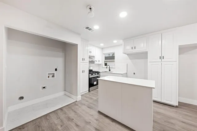 a kitchen with white cabinets and sink