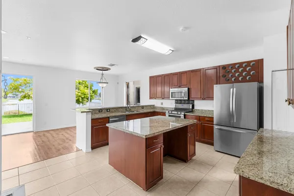 a kitchen with stainless steel appliances granite countertop a sink stove and microwave
