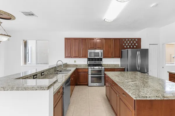 a kitchen with stainless steel appliances granite countertop cabinets and window