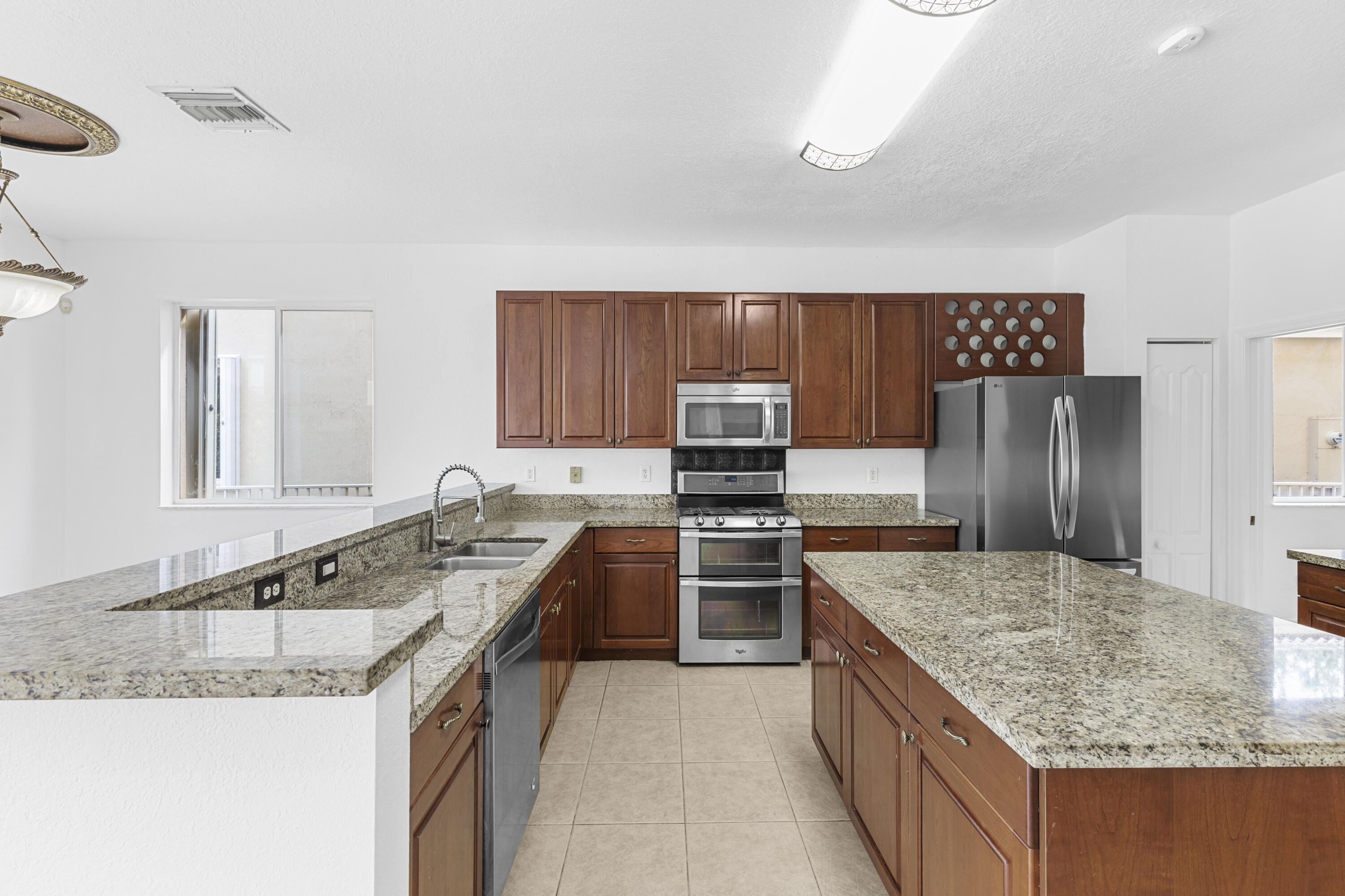 19389 Southwest 64th Street Pembroke Pines, FL 33332 - Photo 8 of 61 a kitchen with granite countertop a sink stove and refrigerator