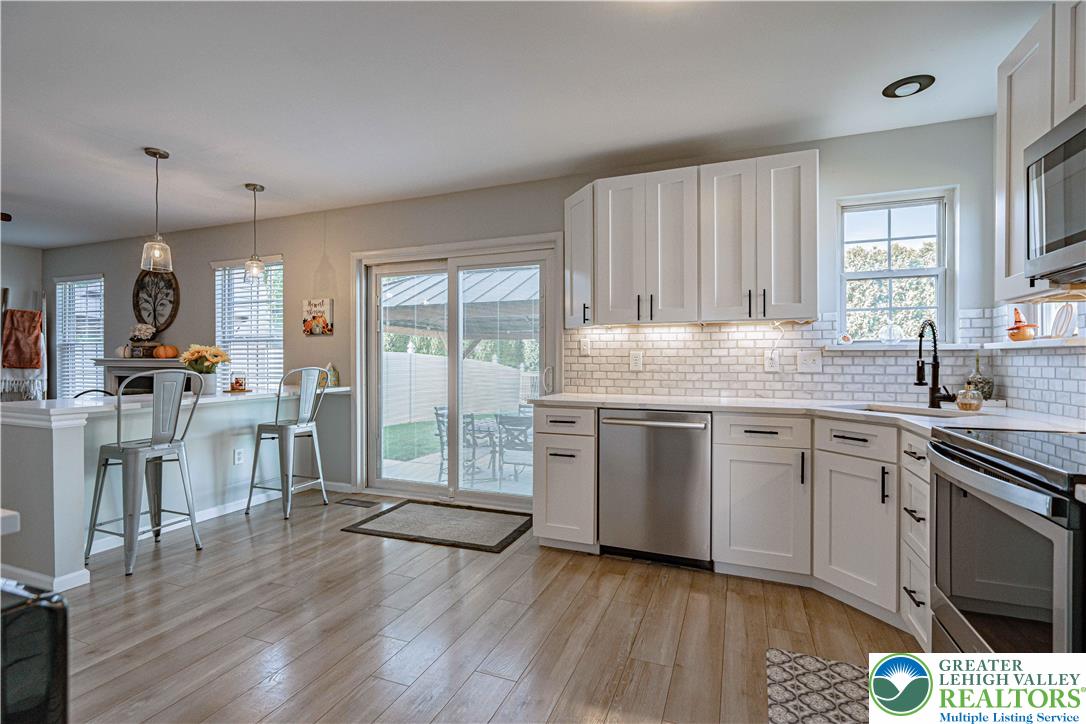 2389 Juniper Drive Coplay, PA 18037 - Photo 11 of 46 a kitchen with granite countertop a stove a sink and white cabinets with wooden floor