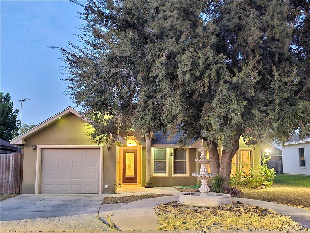 a front view of a house with a tree