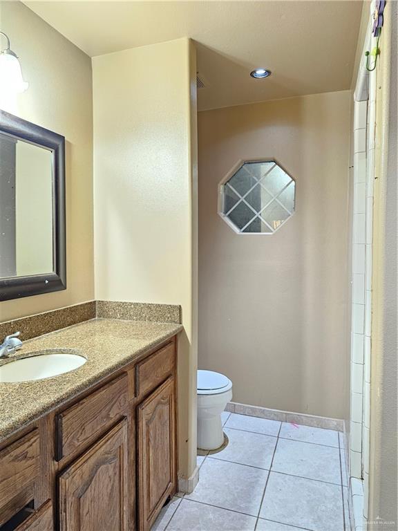 3702 Marla Drive Mission, TX 78572 - Photo 11 of 15 a bathroom with a granite countertop sink a toilet mirror and vanity