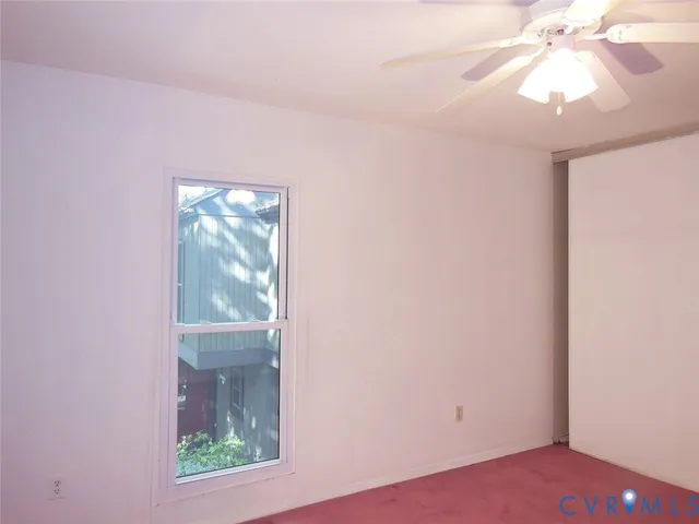 an empty room with a chandelier fan