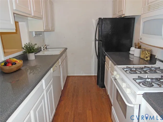 a kitchen with granite countertop a stove and a refrigerator