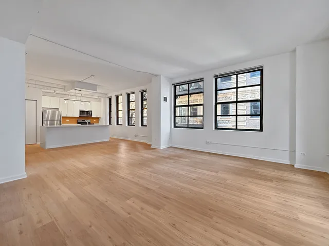 a view of empty room with wooden floor and windows