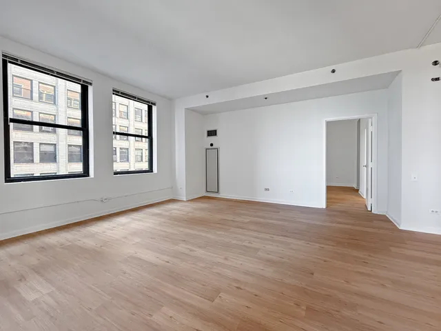 a view of an empty room with wooden floor