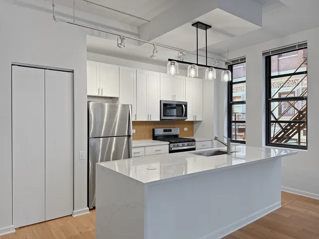 a kitchen with stainless steel appliances a refrigerator sink and microwave