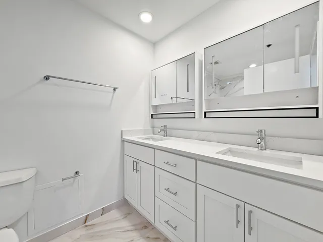 a white toilet and tub sitting next to a bathroom sink