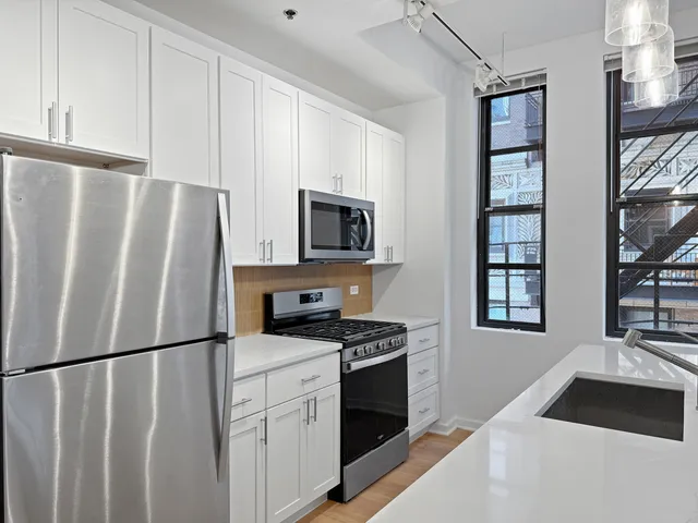 a kitchen with stainless steel appliances a refrigerator stove and microwave