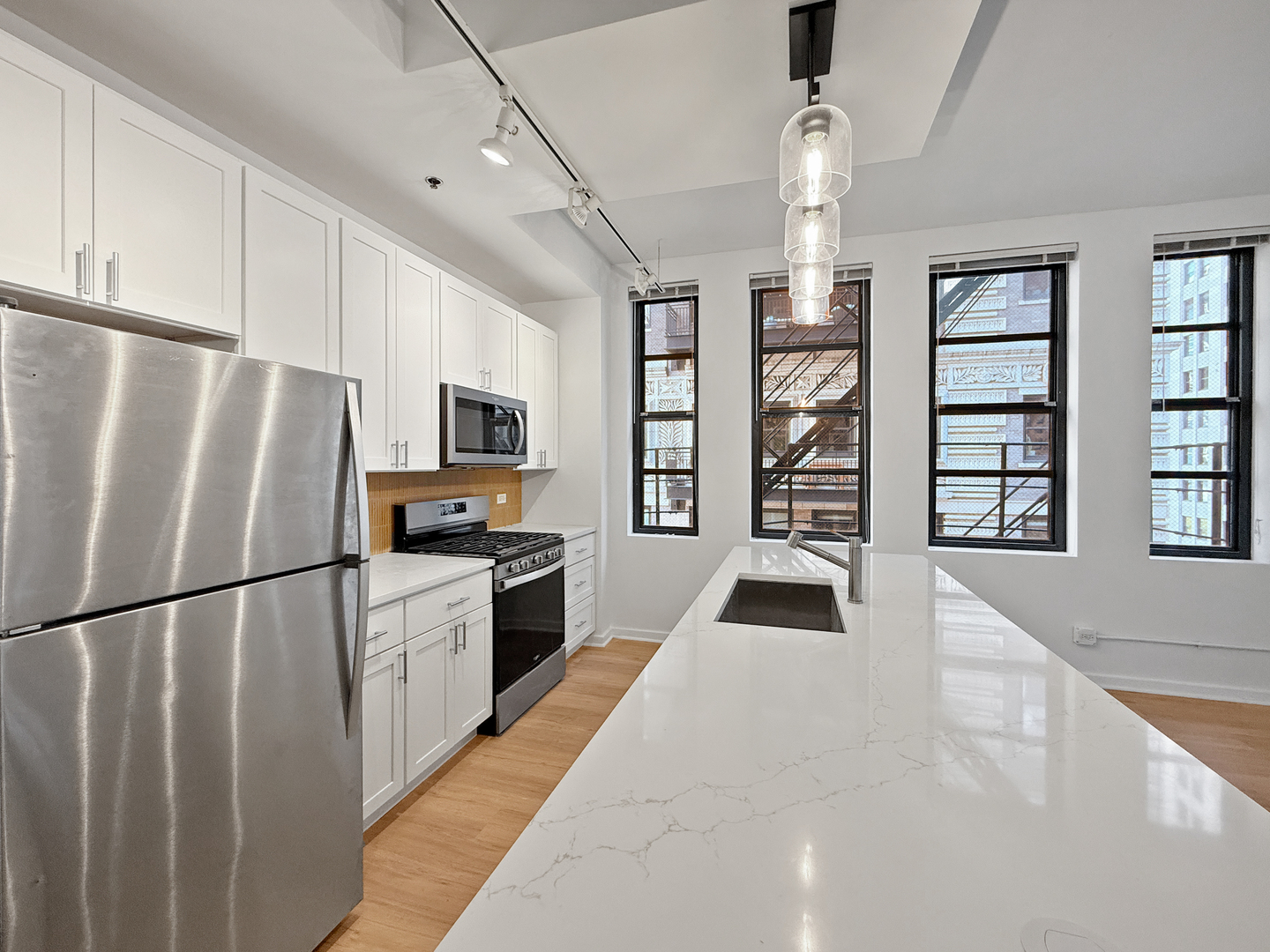 5 North Wabash Avenue, Unit 1201 Chicago, IL 60602 - Photo 4 of 33 a kitchen with granite countertop a refrigerator a oven a sink dishwasher and white cabinets with wooden floor