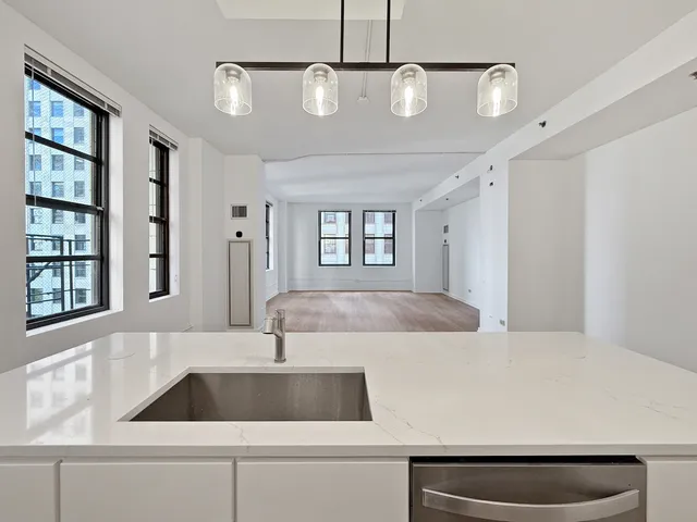 a kitchen that has a lot of cabinets and wooden floor
