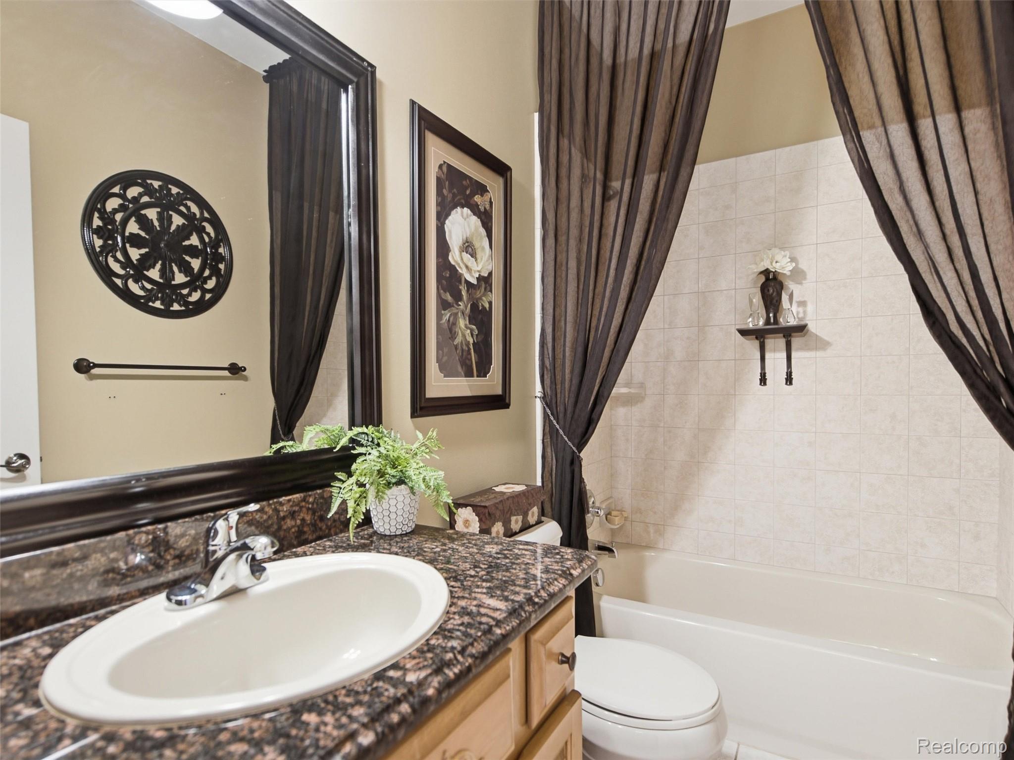 2633 Ridgecrest Drive Utica, MI 48316 - Photo 14 of 28 Second Bathroom featuring custom wood cabinetry, granite counters, ceramic tile and tub/shower combo.