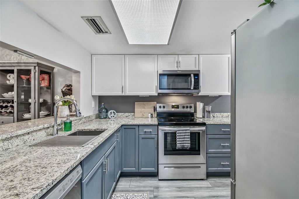 9613 Midiron Court, Unit 39A New Port Richey, FL 34655 - Photo 17 of 76 a kitchen with stainless steel appliances granite countertop a stove a sink and a microwave