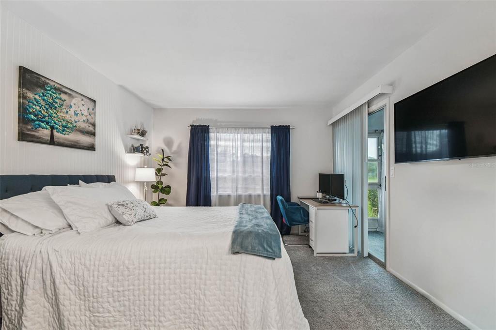 9613 Midiron Court, Unit 39A New Port Richey, FL 34655 - Photo 25 of 76 a bedroom with a large bed and a flat tv screen