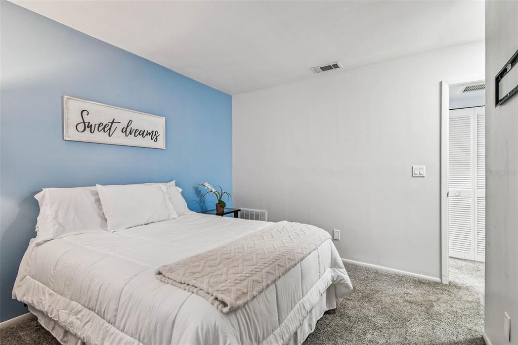 9613 Midiron Court, Unit 39A New Port Richey, FL 34655 - Photo 32 of 76 a bedroom with a bed and a walk in closet