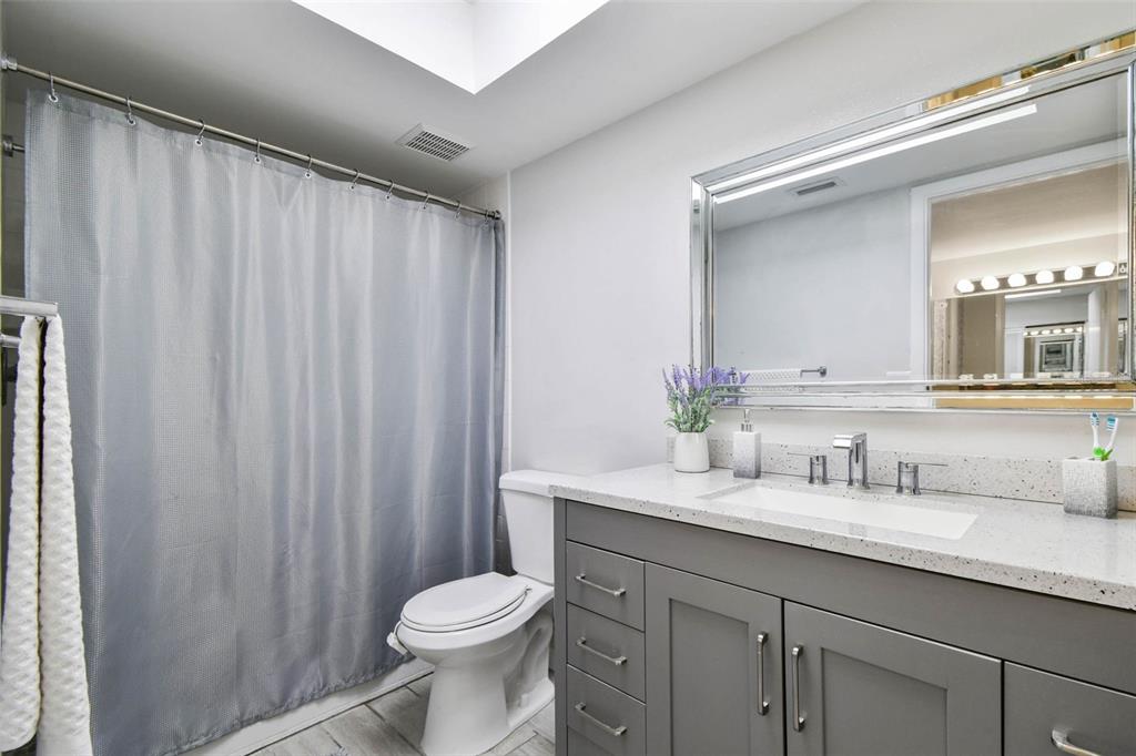 9613 Midiron Court, Unit 39A New Port Richey, FL 34655 - Photo 36 of 76 a bathroom with a sink a toilet a mirror and shower curtain