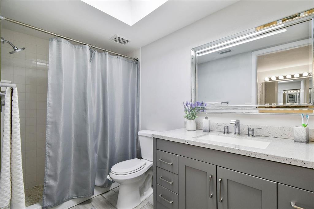 9613 Midiron Court, Unit 39A New Port Richey, FL 34655 - Photo 37 of 76 a bathroom with a sink a toilet a mirror and shower curtain