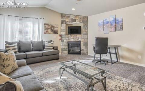 6564 Watusi Road Peyton, CO 80831 - Photo 4 of 12 a living room with furniture a fireplace and a flat screen tv
