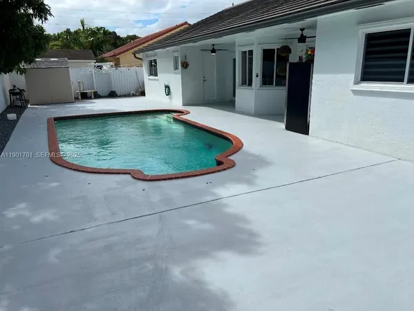 an aerial view of a house with swimming pool and furniture