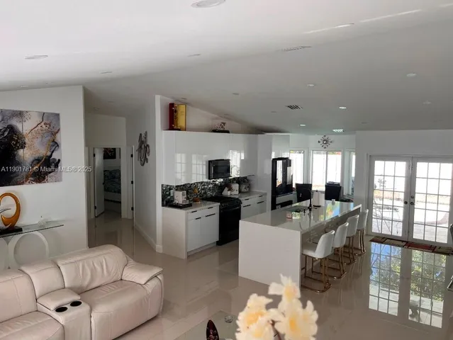 a living room with furniture a flat screen tv and a large window