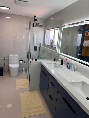 a bathroom with a double vanity sink mirror and toilet