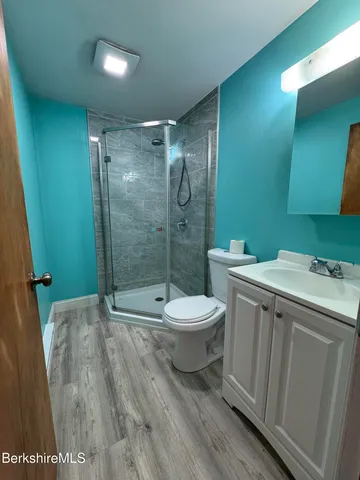 a bathroom with a granite countertop sink toilet and shower