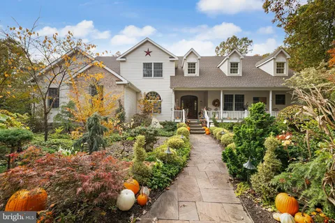 a view of a white house with large windows and flower plants