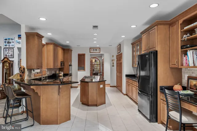 a kitchen with stainless steel appliances granite countertop a refrigerator a sink a stove and a refrigerator
