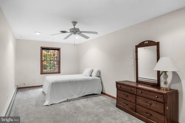 a bedroom with a bed and a lamp with the dresser