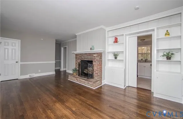 a view of a livingroom with wooden floor and a fireplace