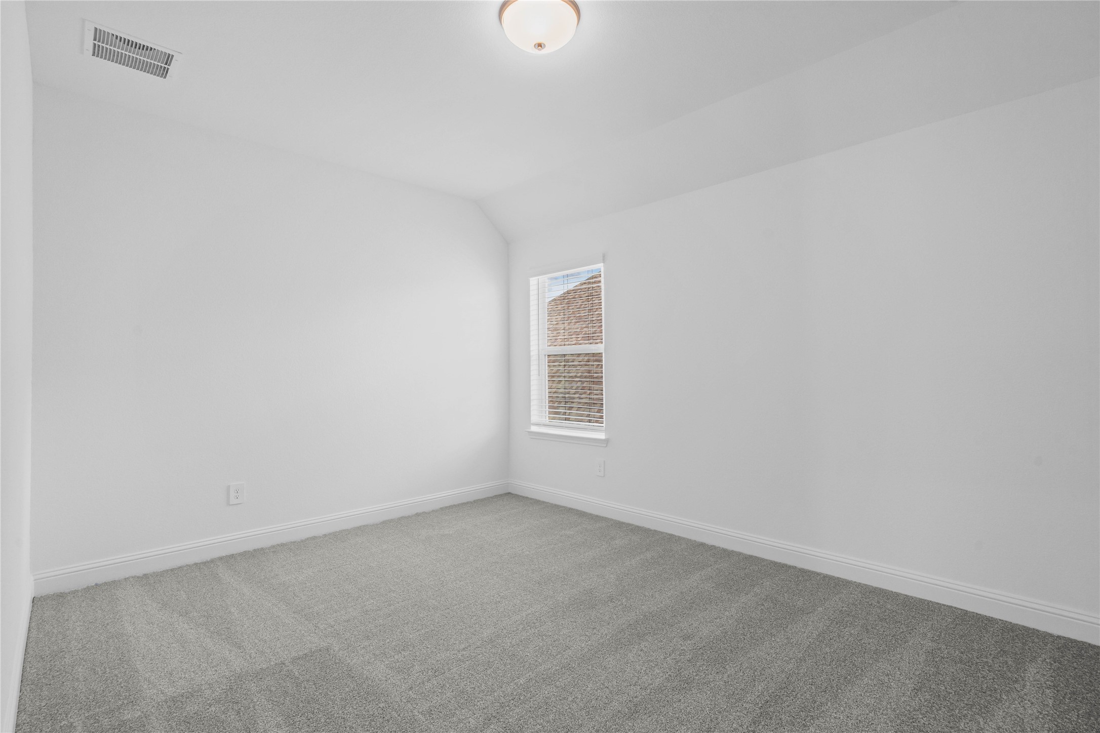 17315 July Moon Lane Conroe, TX 77302 - Photo 37 of 46 This inviting secondary bedroom combines comfort and modern elegance, featuring plush carpeting, a neutral color palette, and abundant natural light streaming through a large window with blinds.
