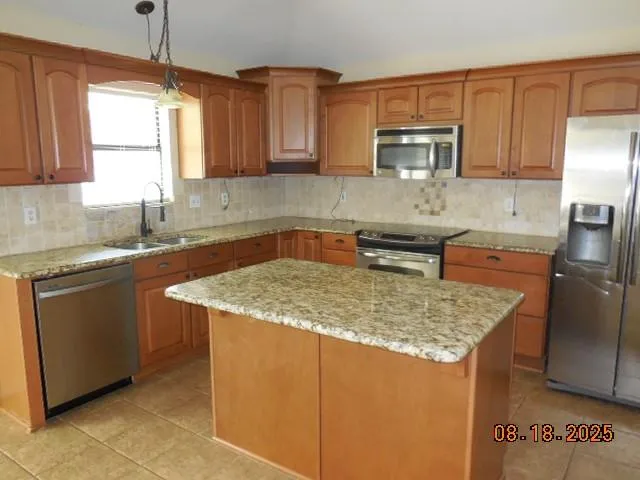 a kitchen with stainless steel appliances granite countertop a sink stove and microwave