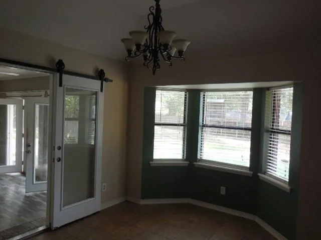 a room with a large window and chandelier