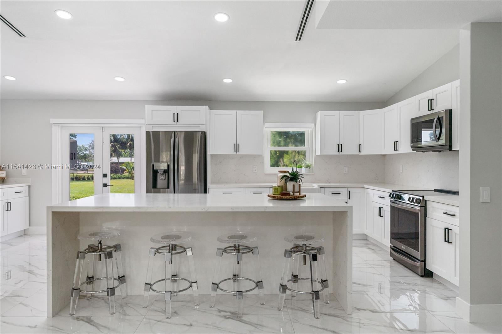 5101 Southwest 199th Avenue Southwest Ranches, FL 33332 - Photo 5 of 22 a kitchen with stainless steel appliances granite countertop a stove top oven a sink a refrigerator and a granite counter tops with white cabinets