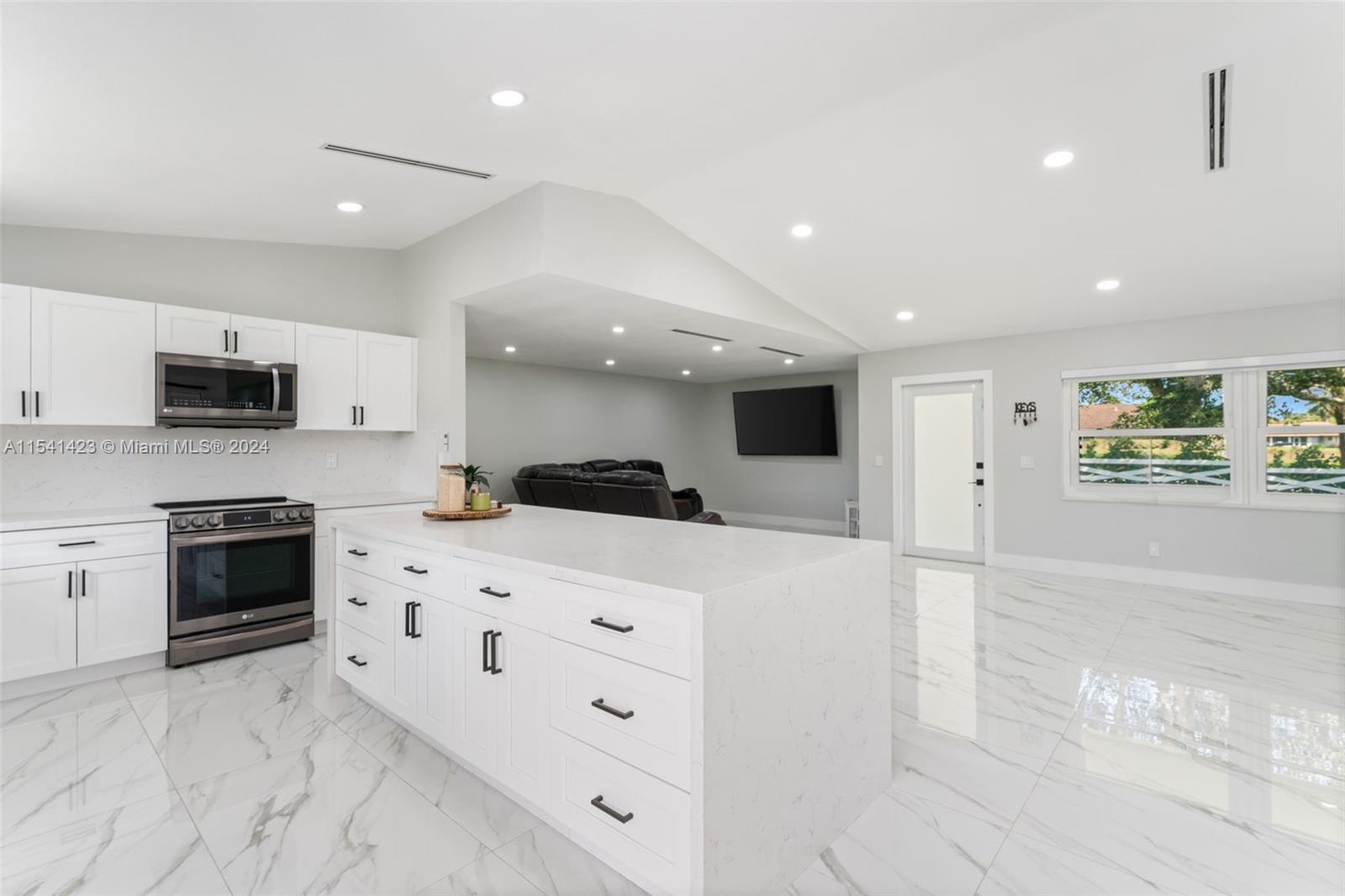 5101 Southwest 199th Avenue Southwest Ranches, FL 33332 - Photo 7 of 22 a large white kitchen with kitchen island a sink stainless steel appliances and cabinets