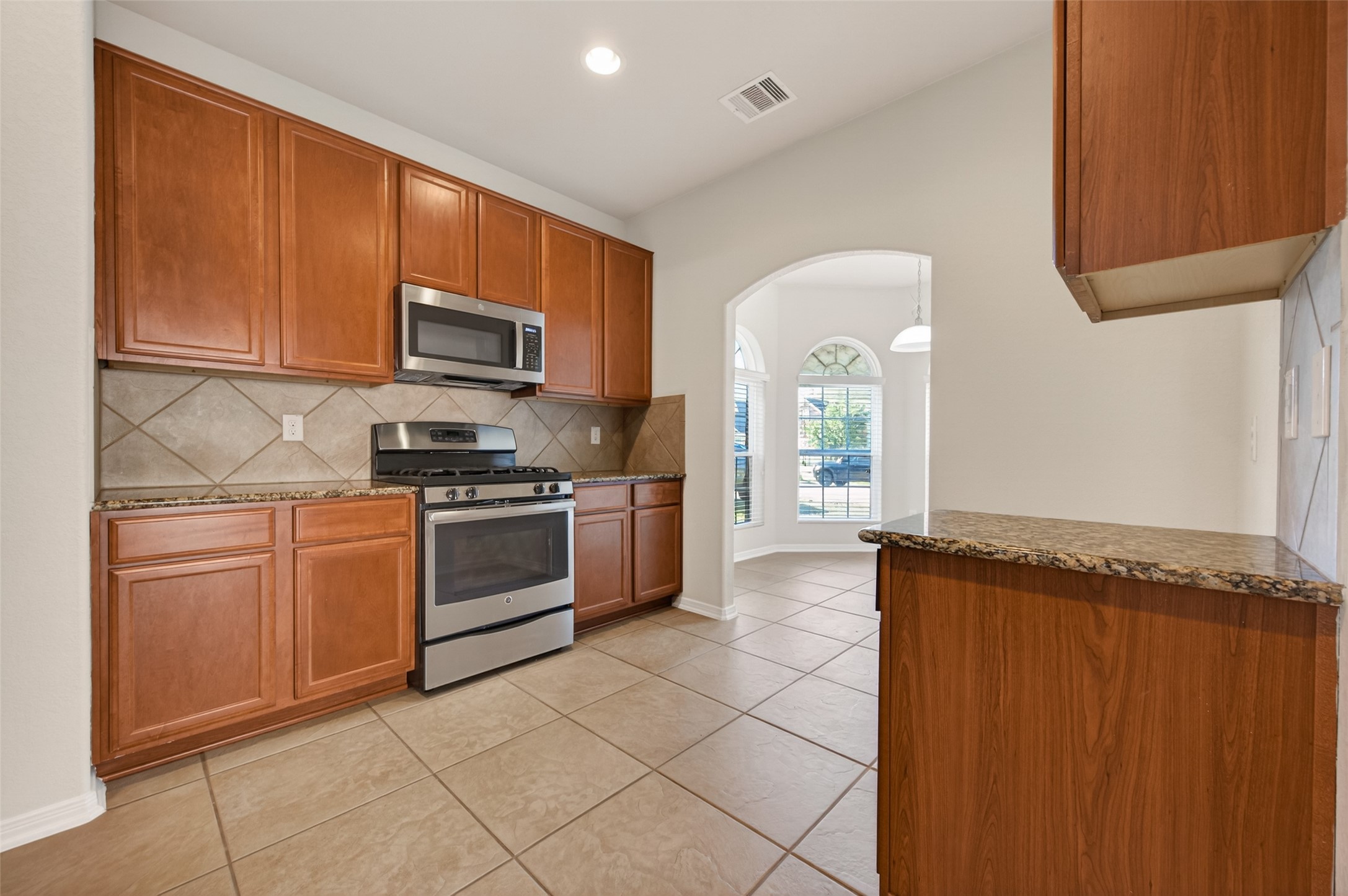 2487 Elm Crossing Trail Spring, TX 77386 - Photo 12 of 46 a kitchen with stainless steel appliances granite countertop a refrigerator and a stove top oven