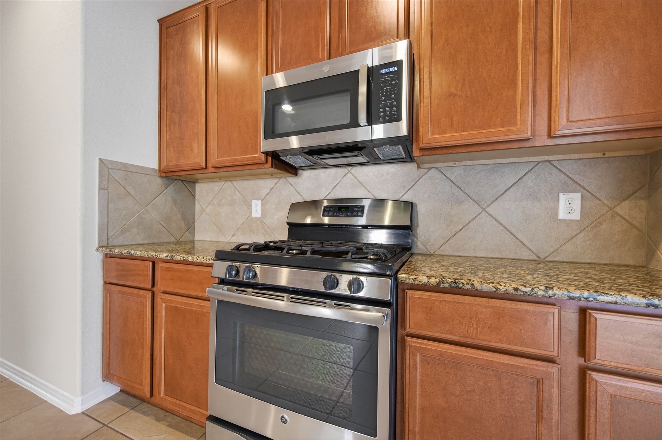 2487 Elm Crossing Trail Spring, TX 77386 - Photo 13 of 46 a kitchen with granite countertop cabinets stainless steel appliances and wooden floor