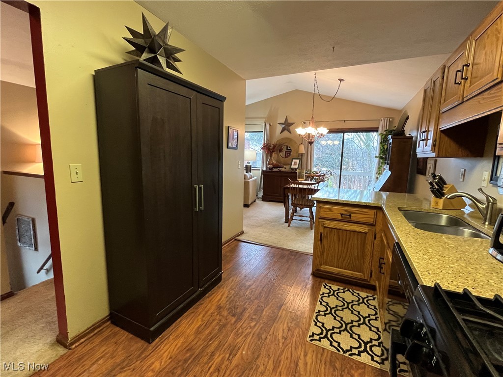 4015 Marks Road, Unit 4B Medina, OH 44256 - Photo 13 of 39 Kitchen featuring sink, vaulted ceiling, dark hardwood / wood-style flooring, an inviting chandelier, and decorative light fixtures