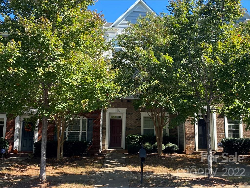 a front view of a house with a tree